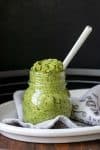 Glass jar with pesto and a spoon inside