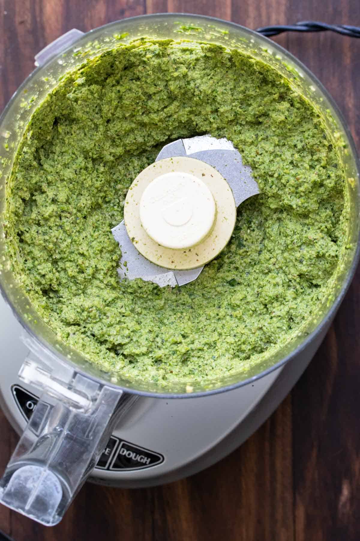 Top view of a food processor with pesto inside