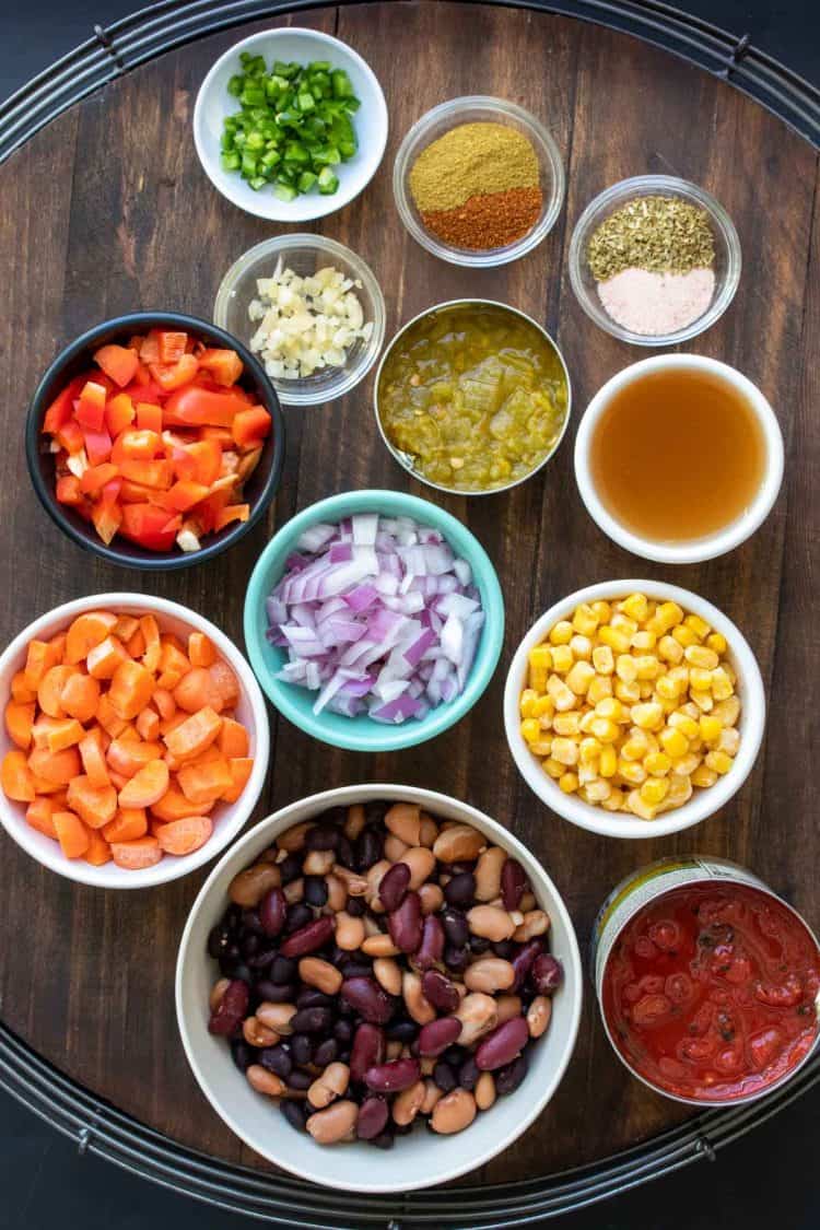 Different color and size bowls filled with ingredients to make veggie chili