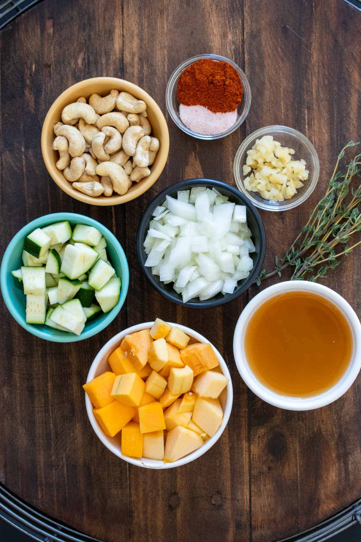 Different colored bowls filled with ingredients needed to make winter squash soup