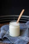 Wooden spoon in a glass jar filled with coconut butter.