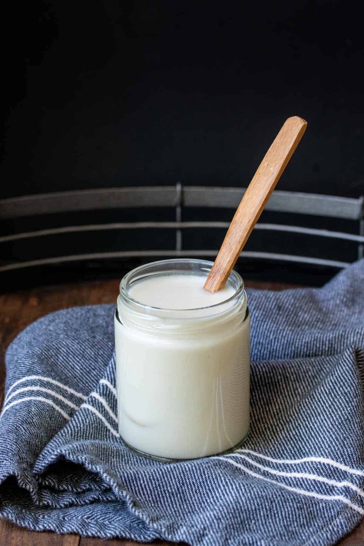 Wooden spoon in a glass jar filled with coconut butter.