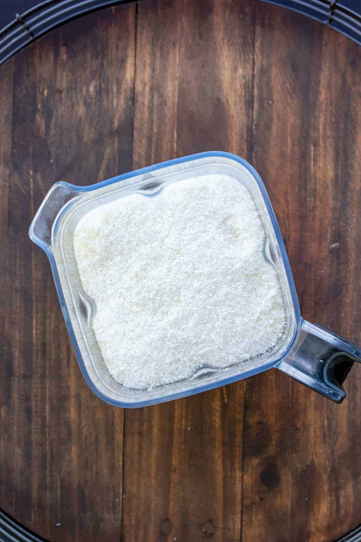 Top view of blender filled with shredded coconut.