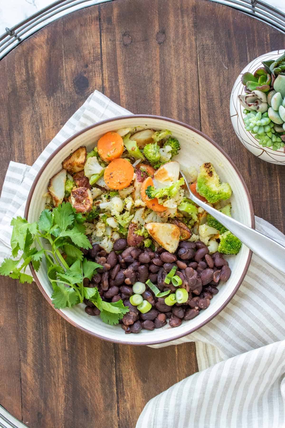 Plate with black beans next to a mix of veggies