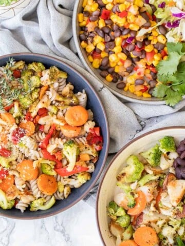 Close up of three bowls filled with different meals using veggies and other ingredients