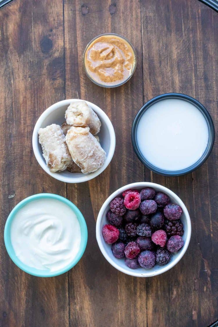 Bowls with ingredients needed to make a dairy free banana berry smoothie