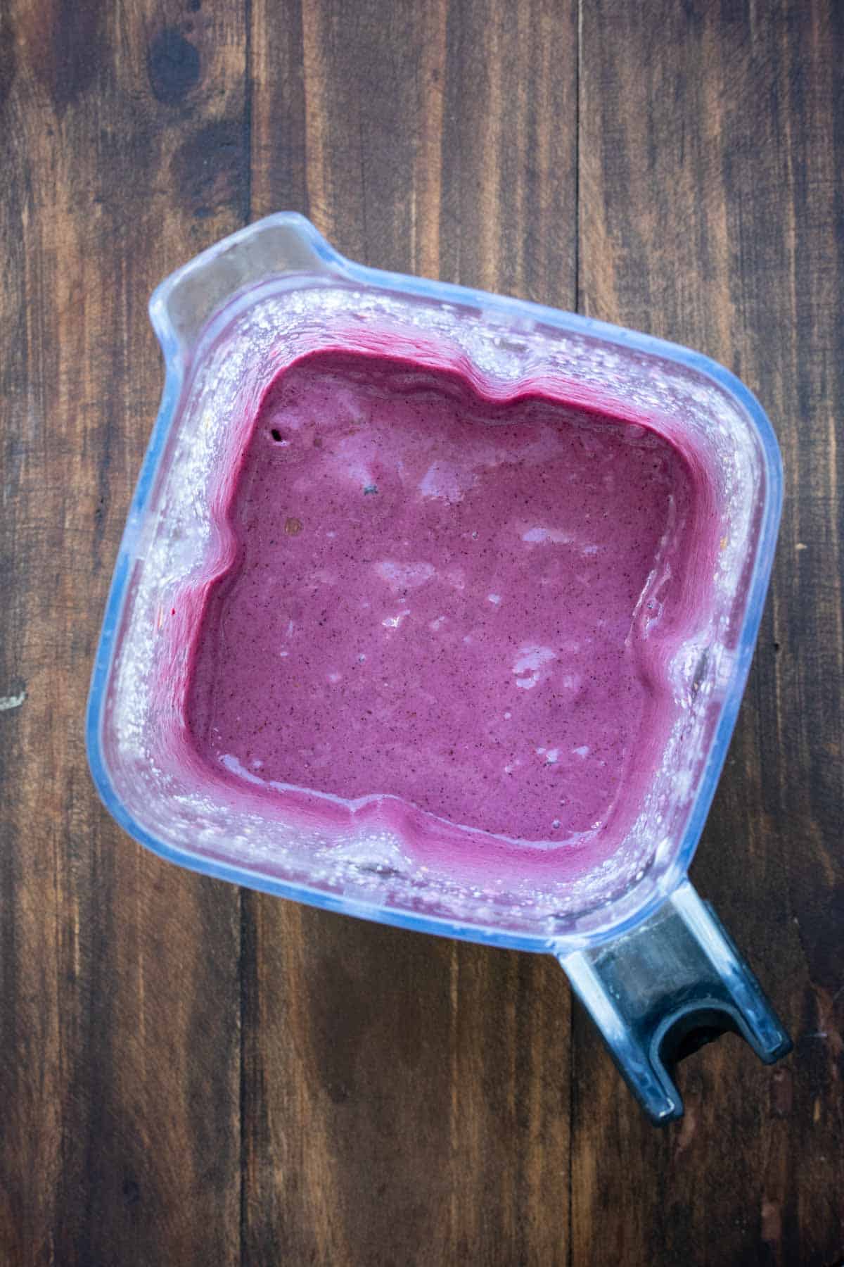 Top view of a blender with a purple banana berry smoothie in it