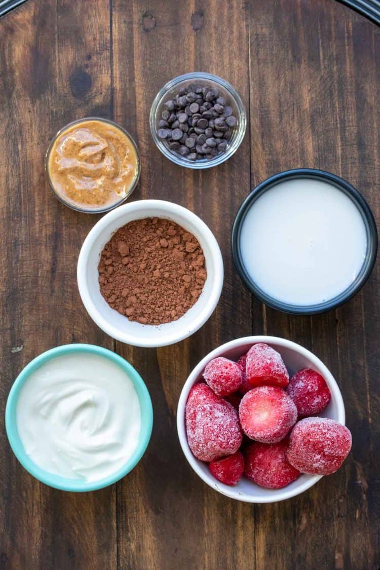 Bowls filled with ingredients to make a dairy free chocolate strawberry smoothie