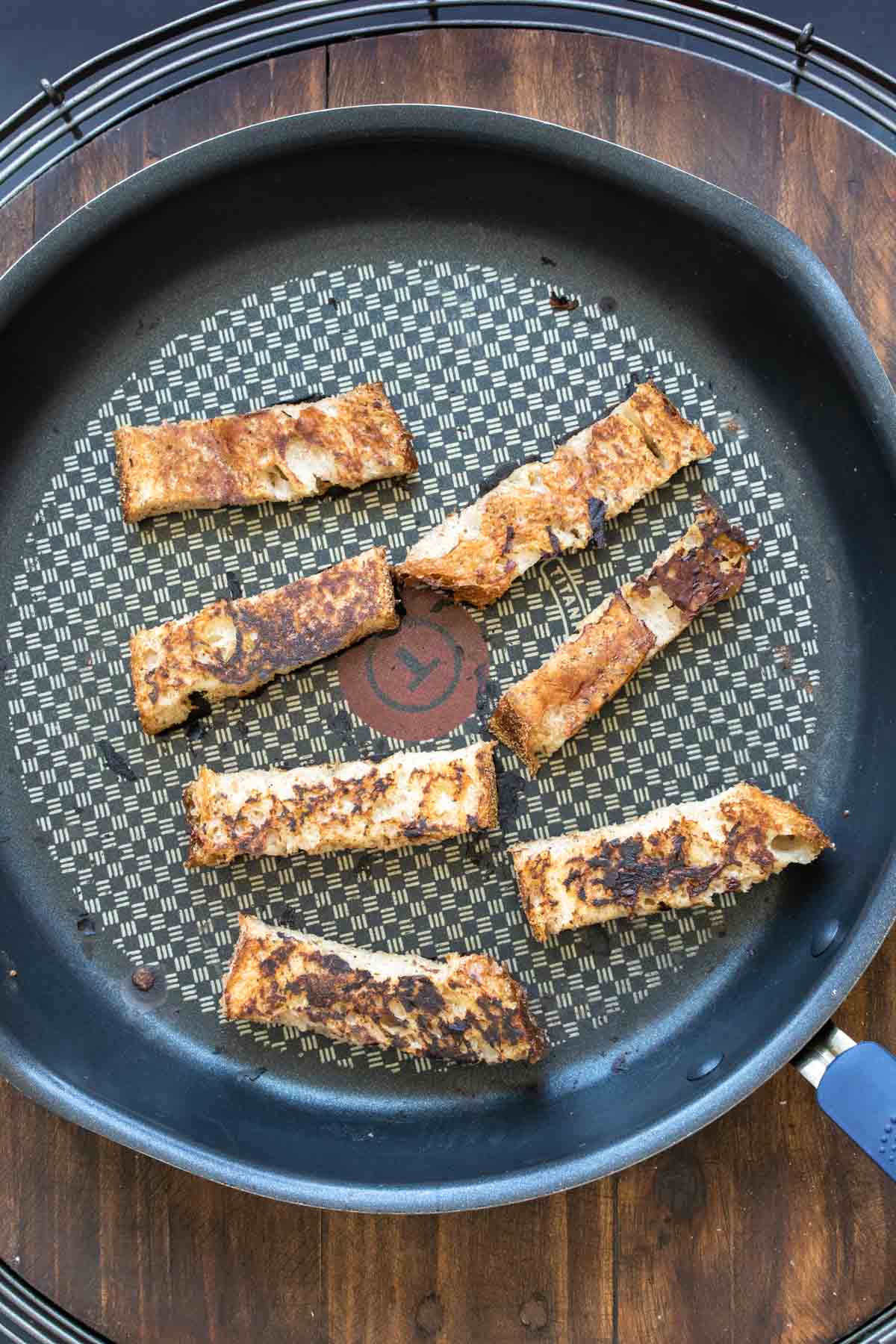 French toast stick cooking on a pan until crispy