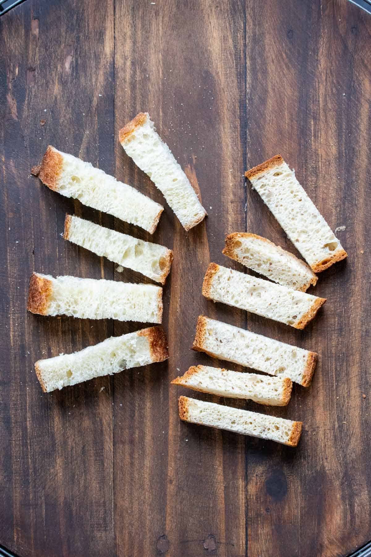 Thick strips of bread laying on a wooden surface