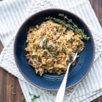 Dark blue bowl on a cream towel filled with mushroom risotto.