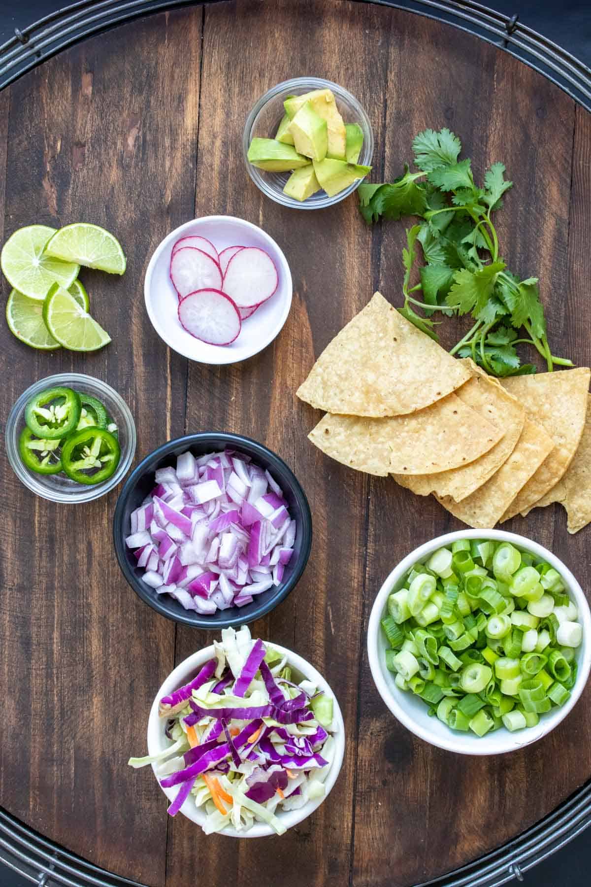 Toppings laid out on a wooden surface that you can use for pozole soup.