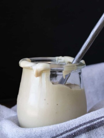 Knife in a glass jar filled with cream cheese frosting