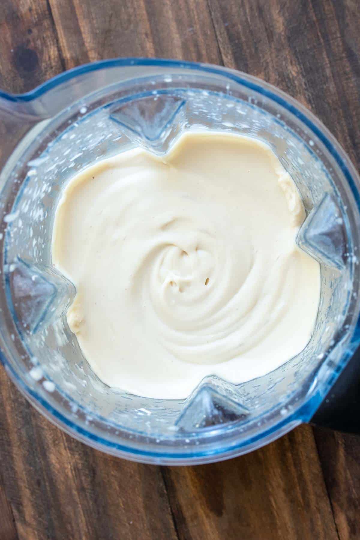 Top view of creamy white mixture in a blender