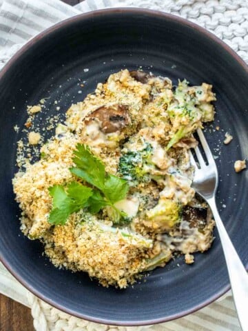 Blue plate with a serving of broccoli casserole and a fork.