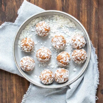 Carrot cake energy balls covered in shredded coconut and spread out on a plate