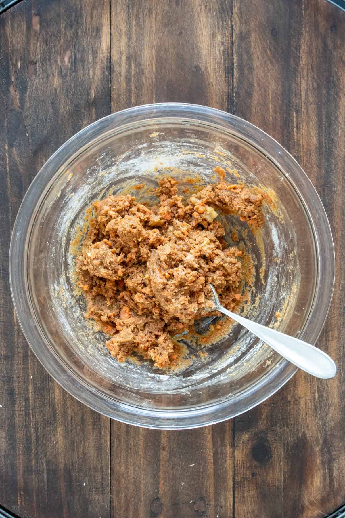 Spoon in a glass bowl mixing a batter