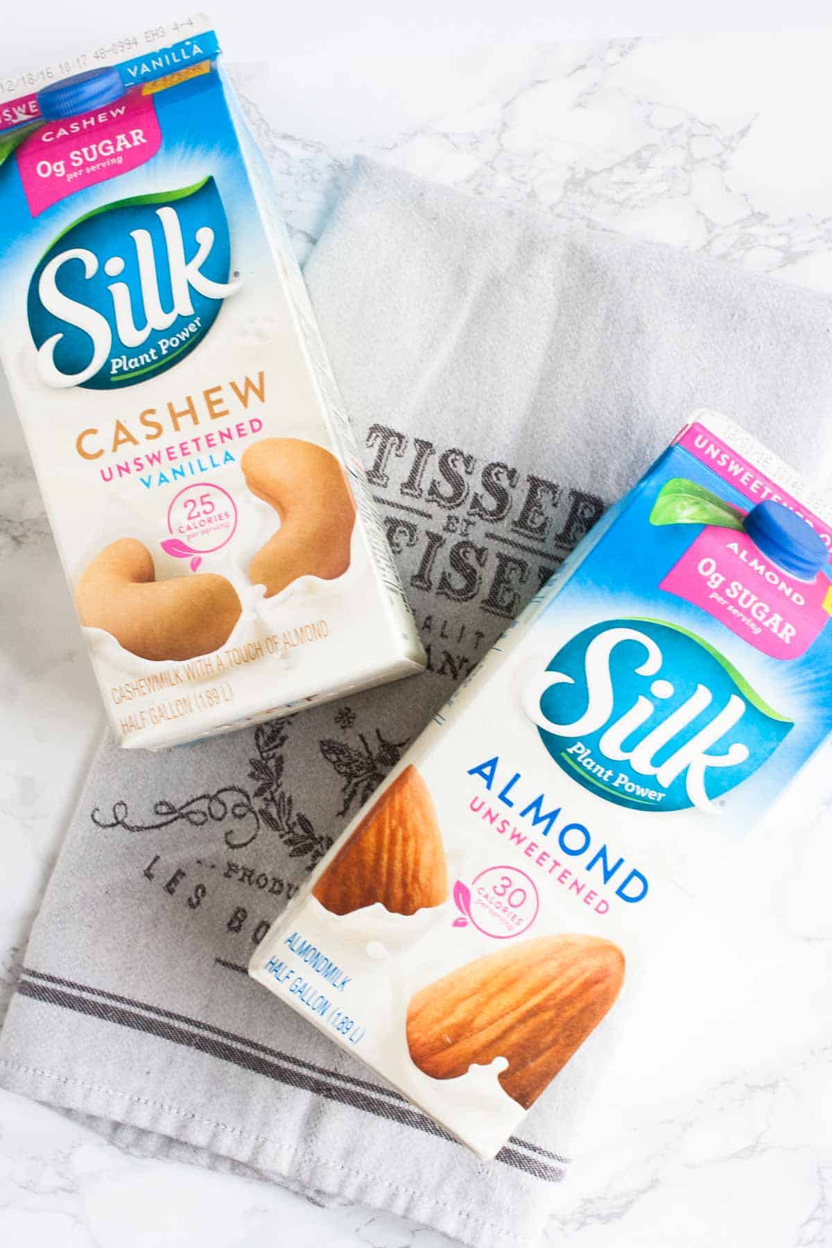 Silk dairy free milk containers laying on a grey towel
