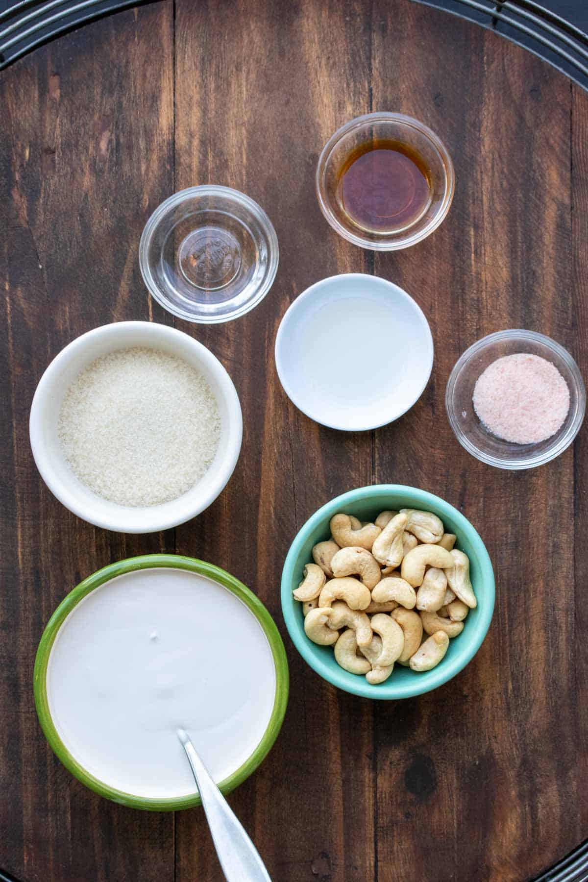 Different colored bowls with ingredients to make a cashew based dairy free cream cheese frosting