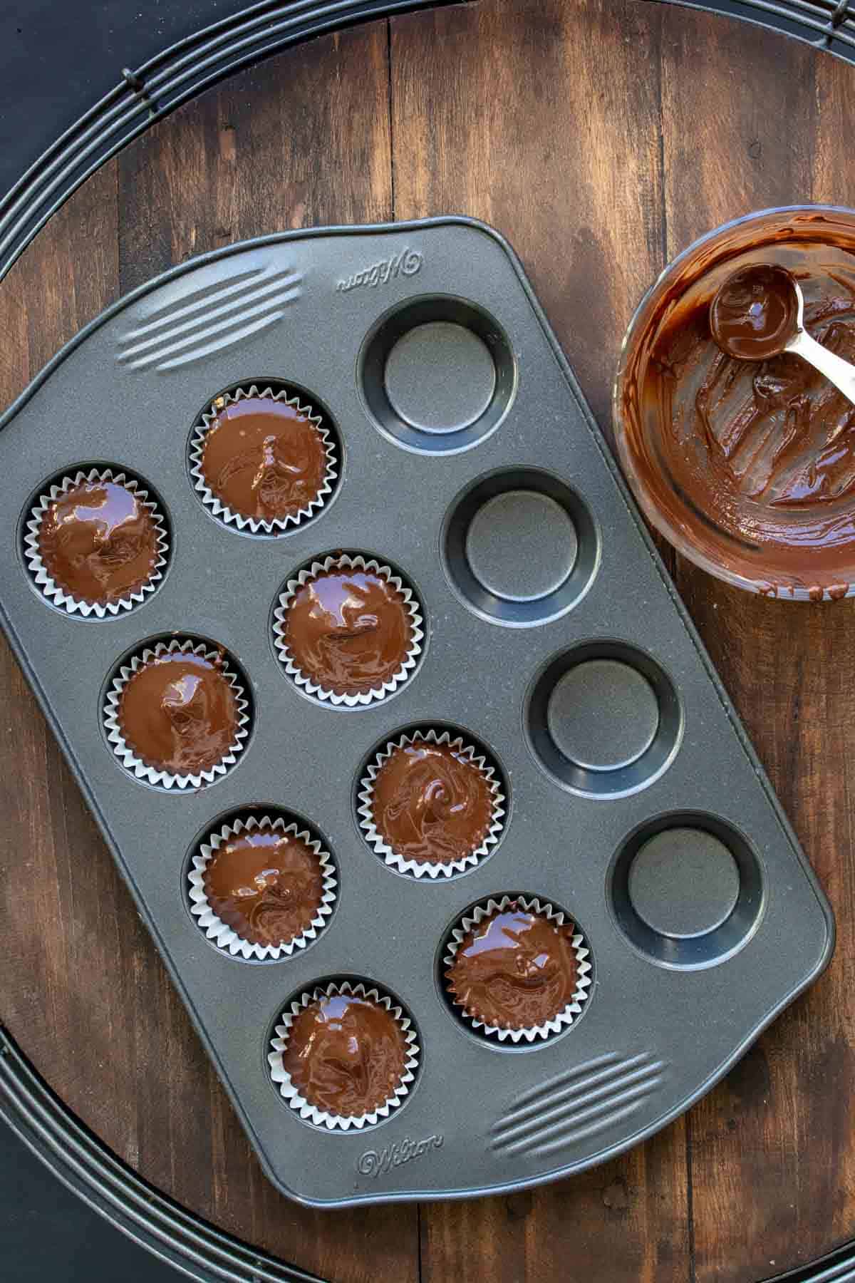 Mini muffin tin with peanut butter cups being made in it