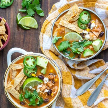 Two bowls filled with tortilla soup and loaded with toppings