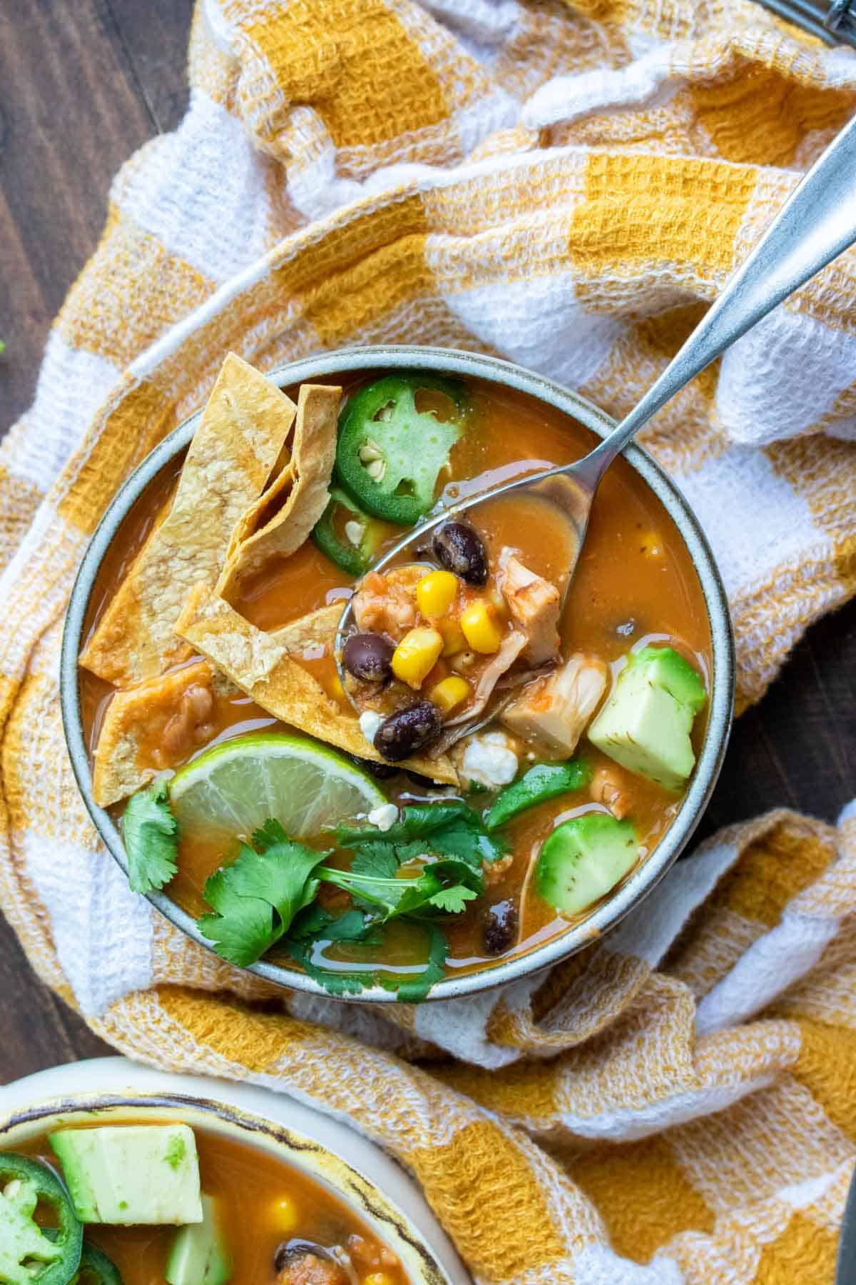 Spoon getting a bite of tortilla soup from a soup bowl