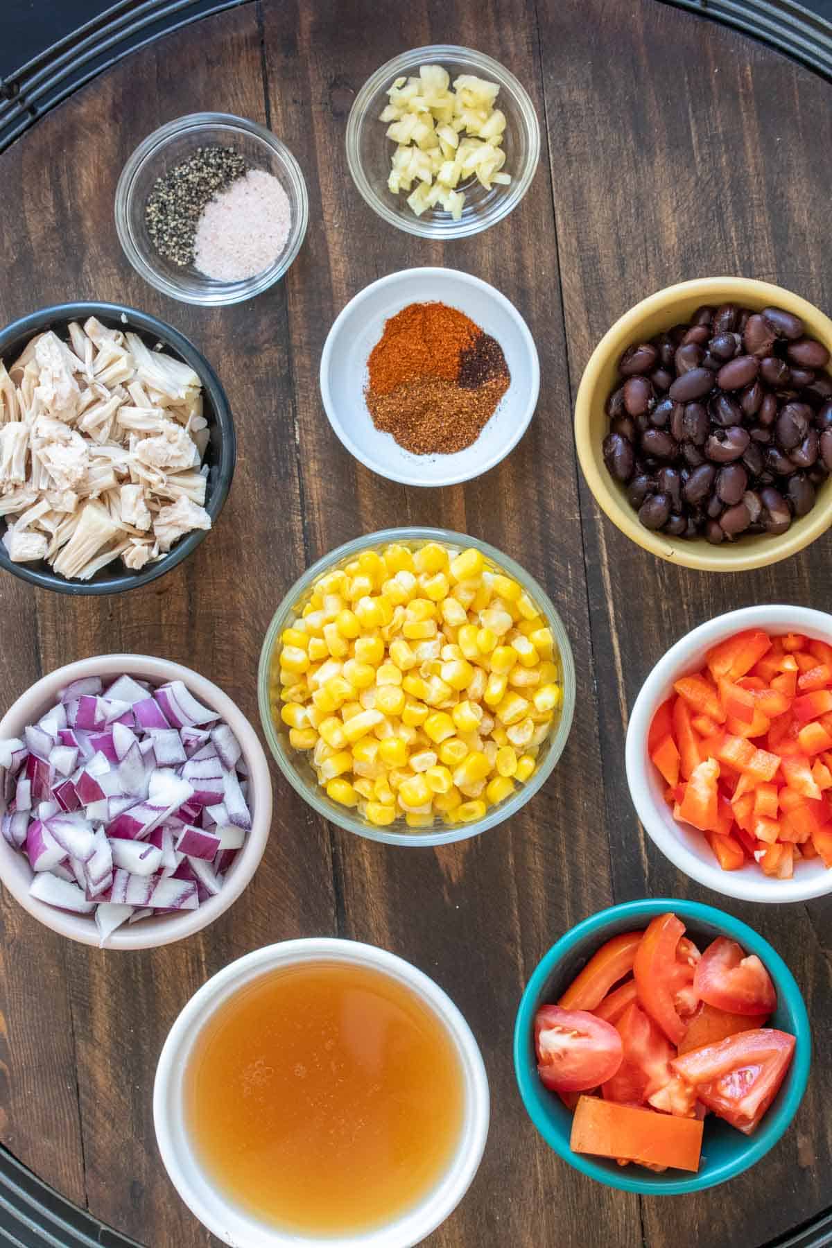 Bowls with ingredients needed to make a Mexican tortilla soup