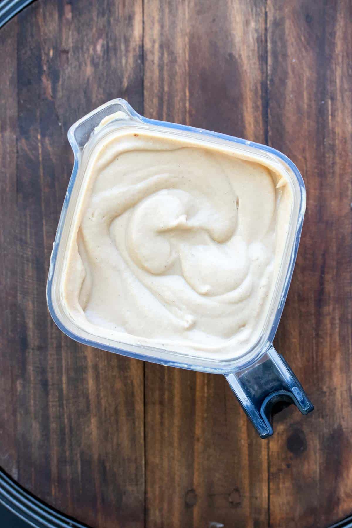 Top view of a blender with pureed white soup in it