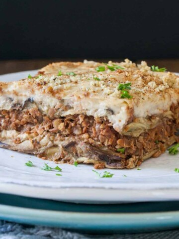 White plate with a piece of lentil based moussaka on it.