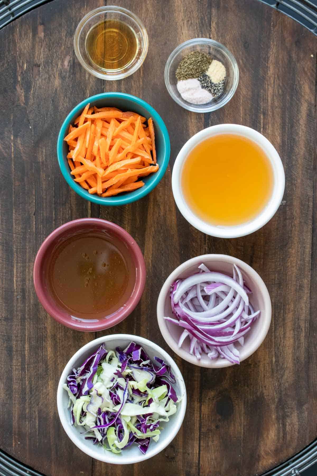 Colored bowls with ingredients needed to make a vinegar slaw