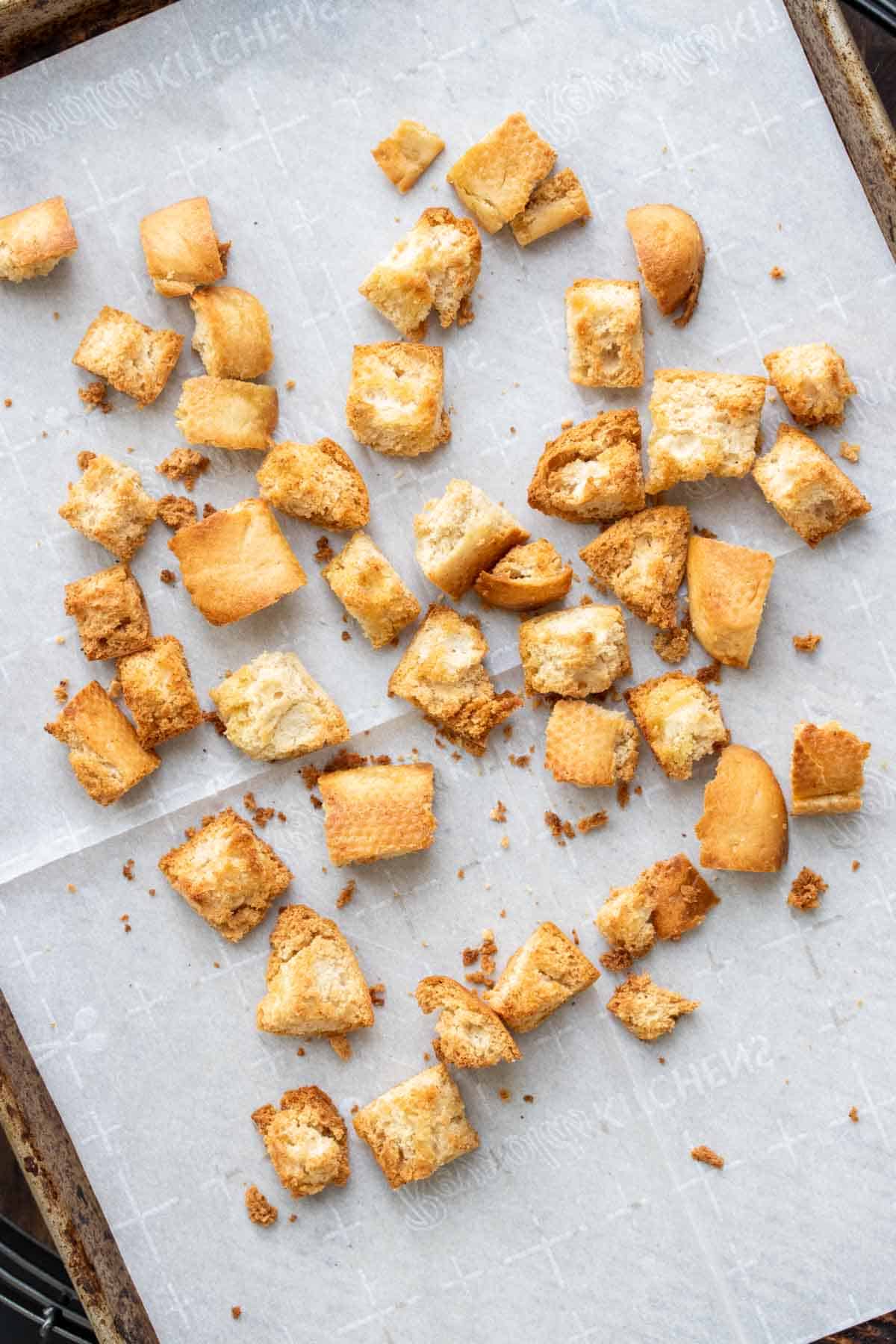 Top view of baked croutons on a piece of parchment