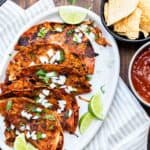 White platter with five pan fried birria tacos on it