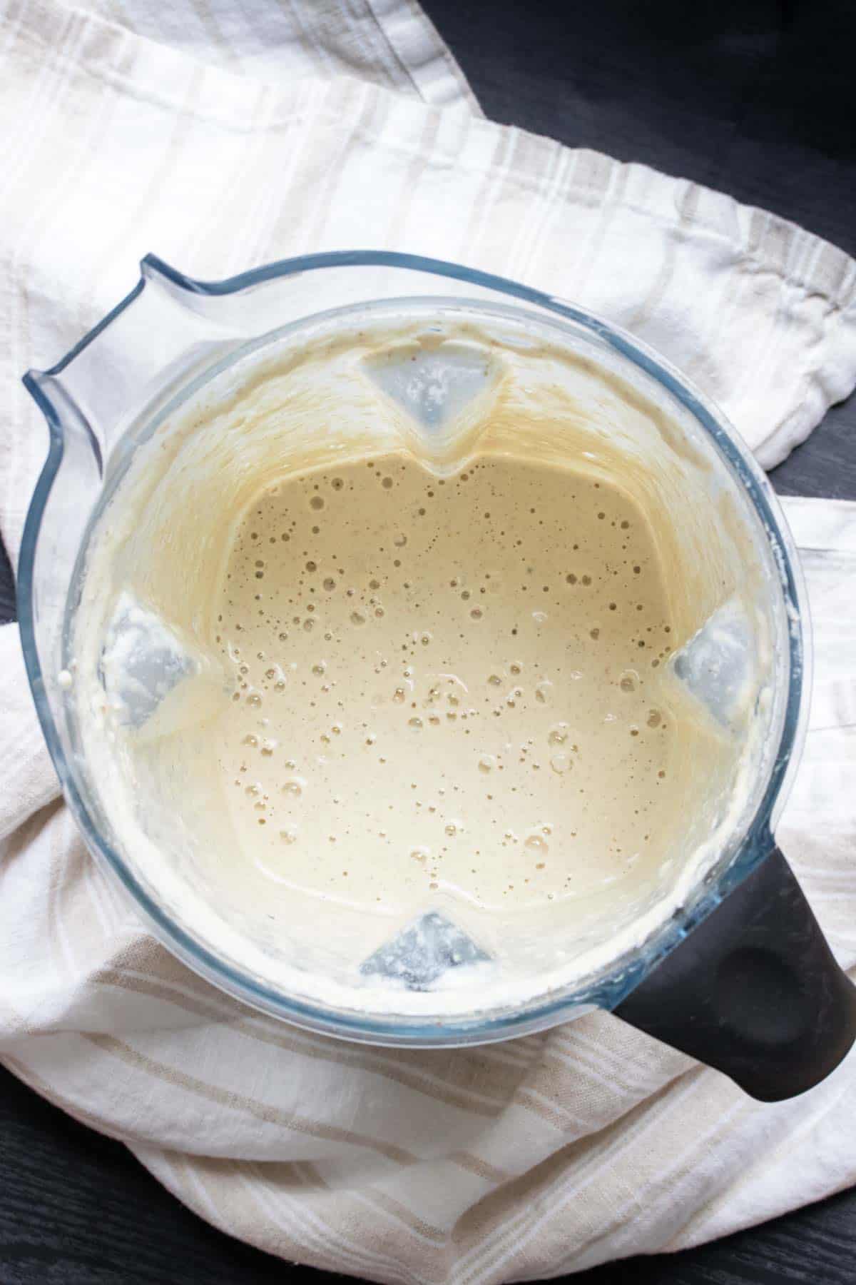 Top view of a blender with creamy white dressing inside