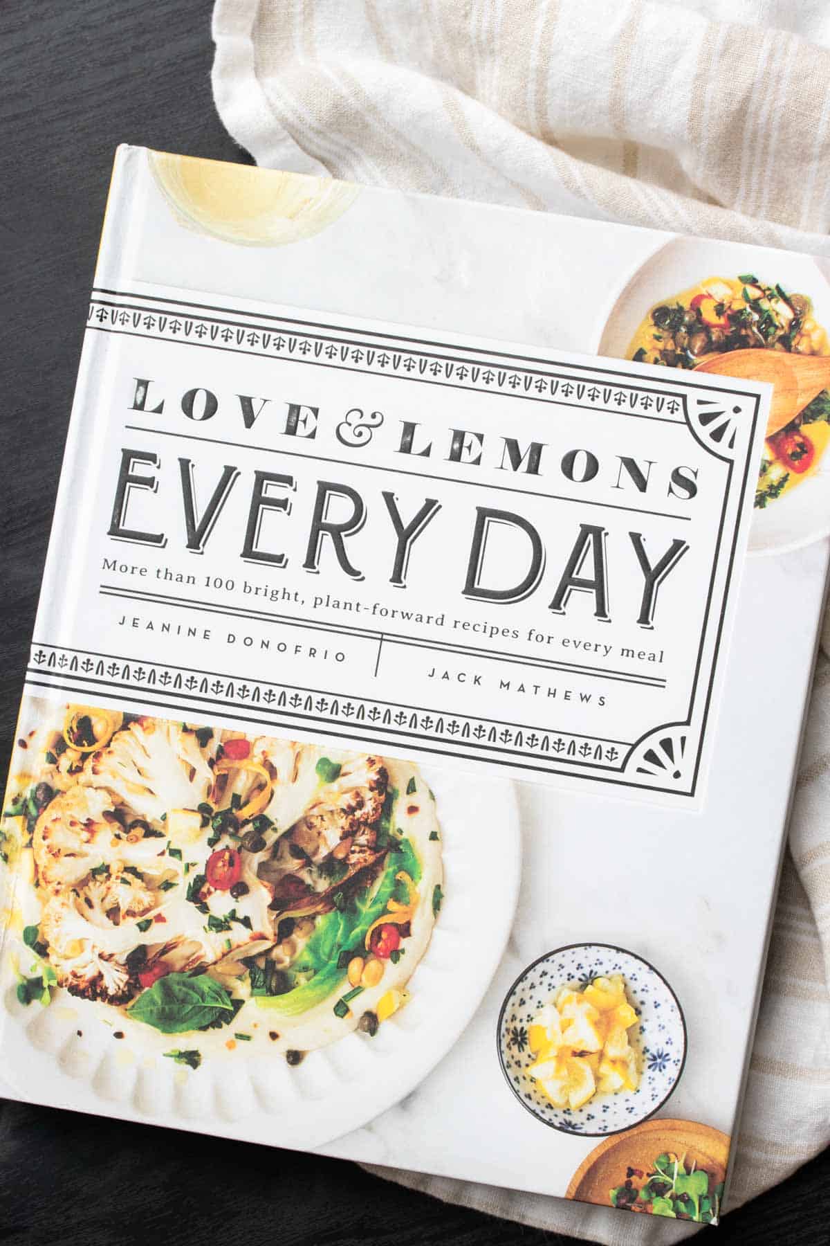 Cover of a white cookbook with a photo of grilled cauliflower on it