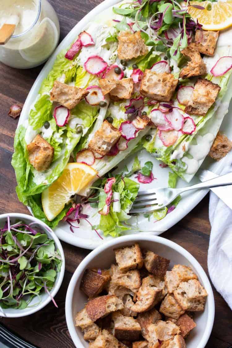 Grilled hearts of romaine lettuce topped with ingredients and dressing