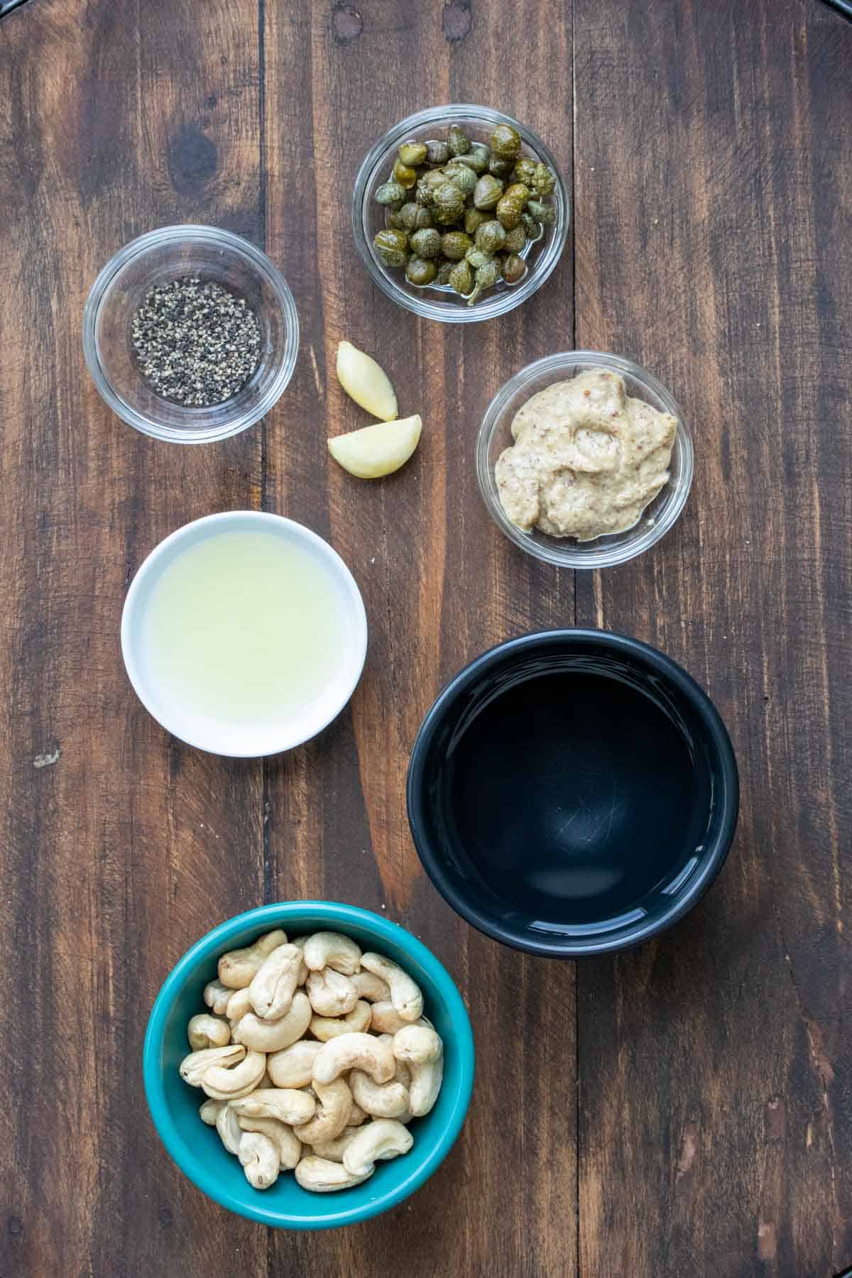 Ingredients needed for a cashew based Caesar dressing in bowls