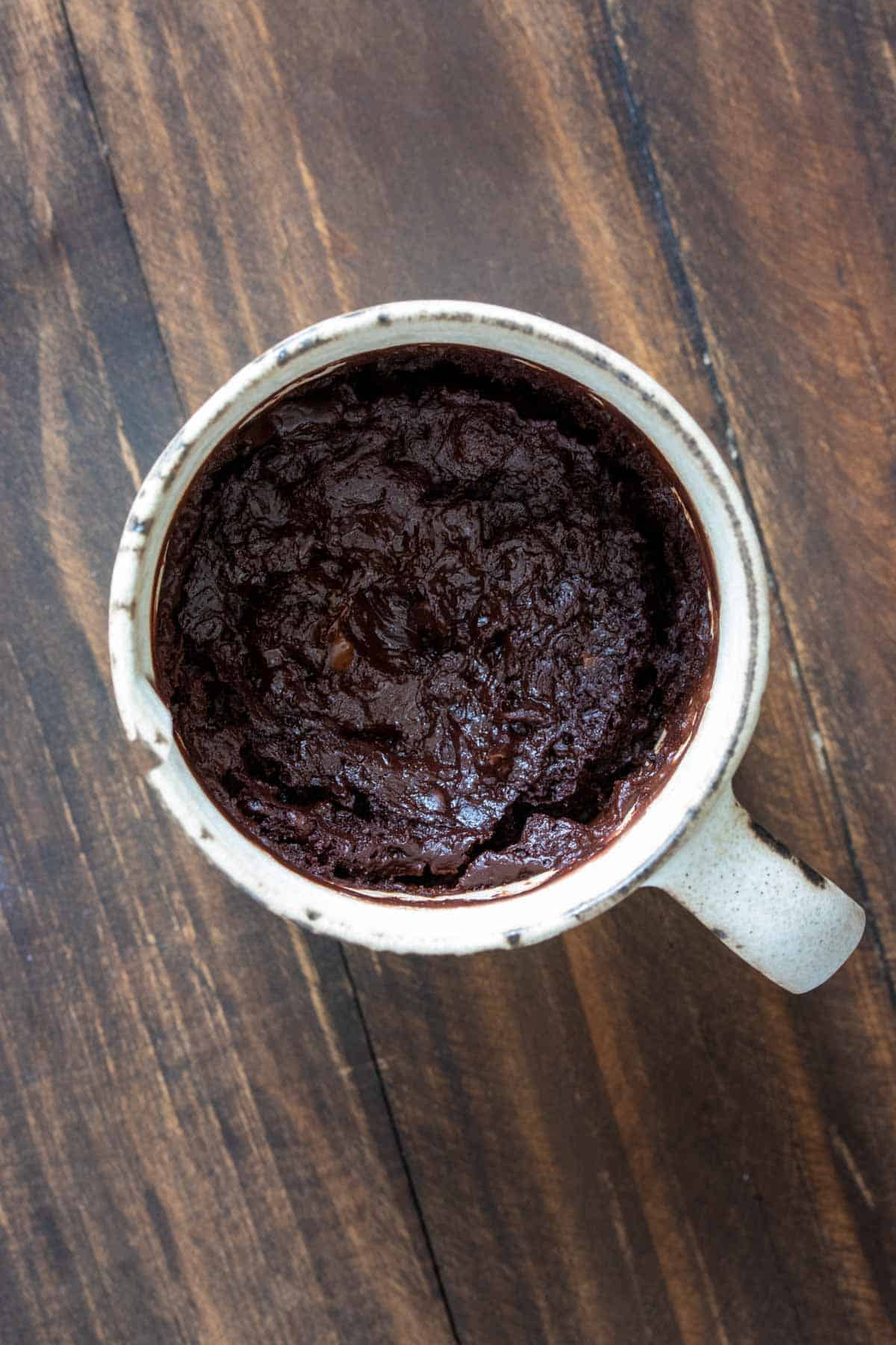 Top view of cooked chocolate cake in a cream mug