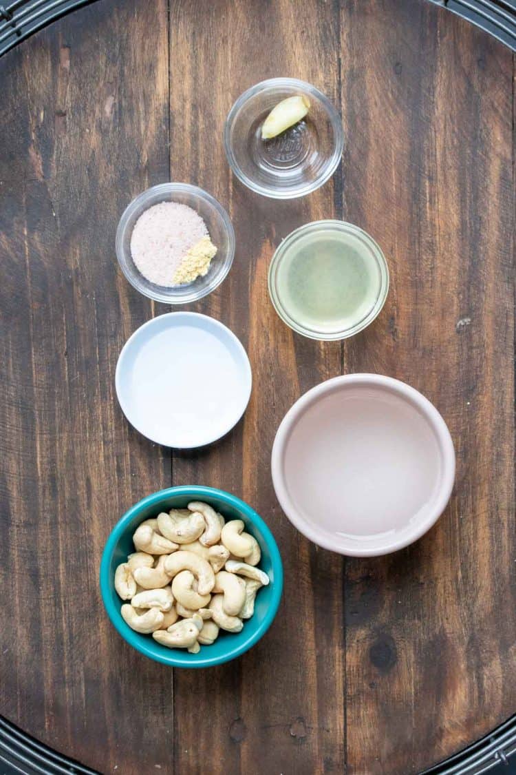 Colored bowls with ingredients to make a cashew based homemade mayo