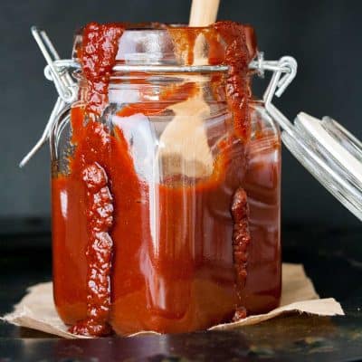 Glass storage jar with bbq sauce in it and running down the sides