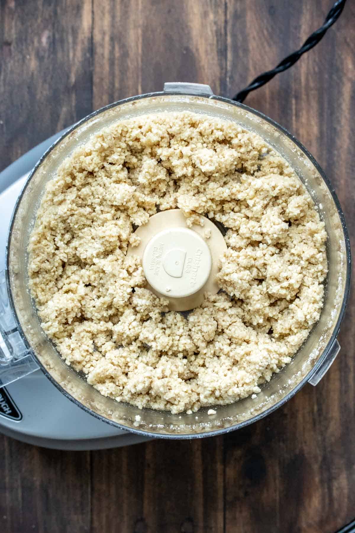 Top view of a food processor with grated Parmesan from cashews.