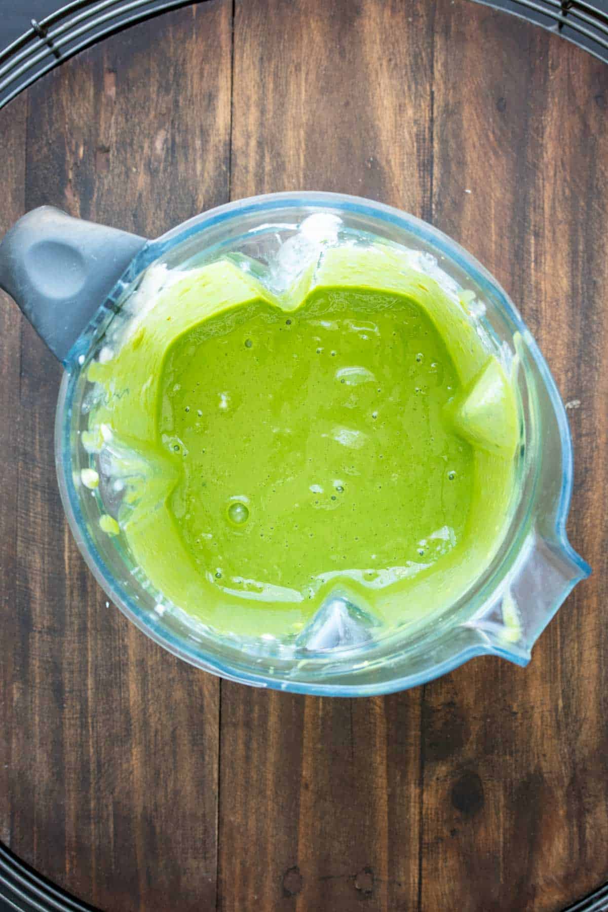 Top view of a blender with a green smoothie inside