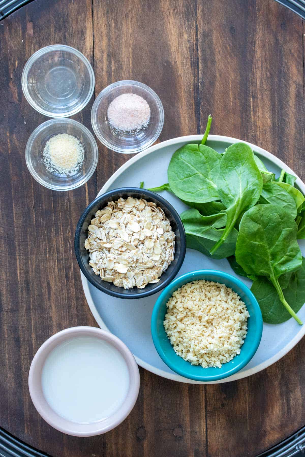 Plate and bowls with ingredients needed to make a spinach oatmeal