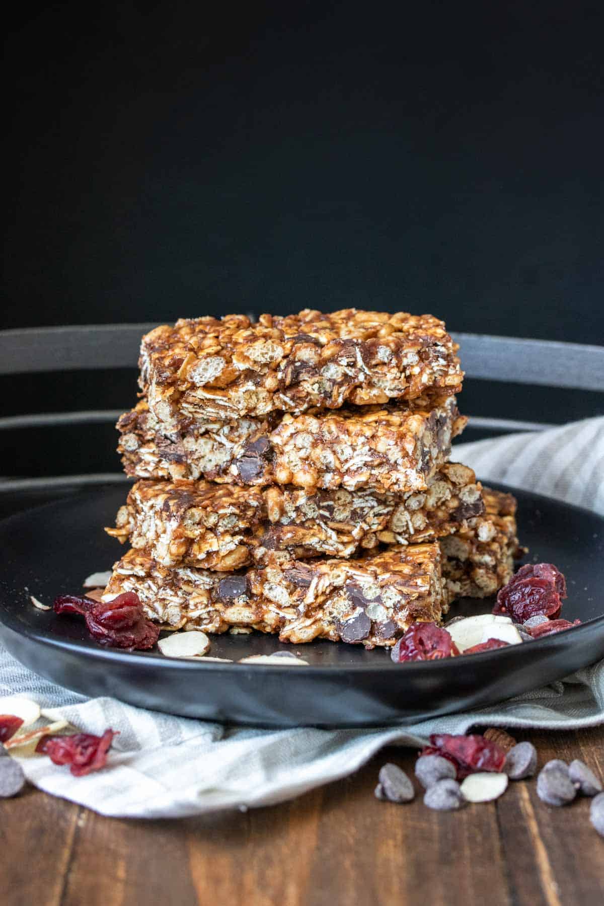 A stack of granola bars on a black plate laying on a kitchen towel