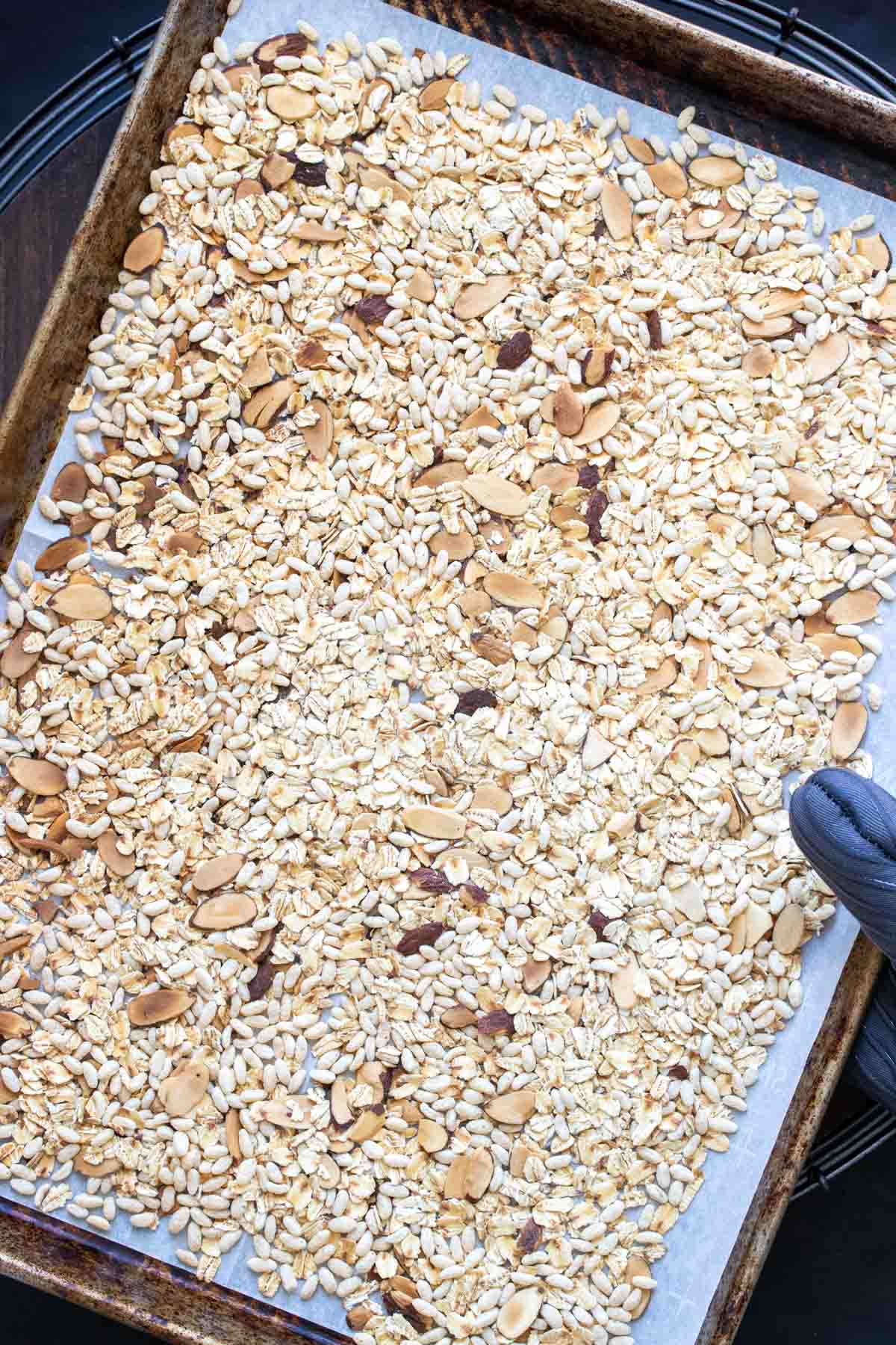 Baking sheet with oats, rice cereal and sliced almonds on it