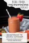 Orange smoothie in a jar with a strawberry on the rim and overlay text on wellness