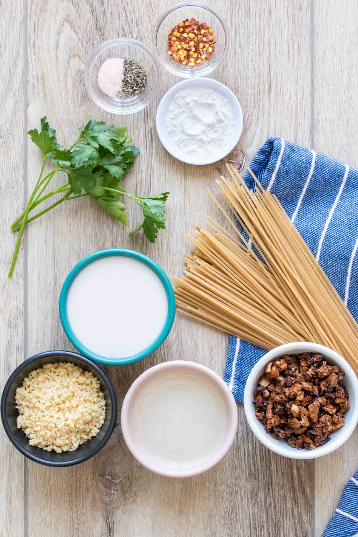 Ingredients needed to make a dairy free spaghetti carbonara on a wooden surface