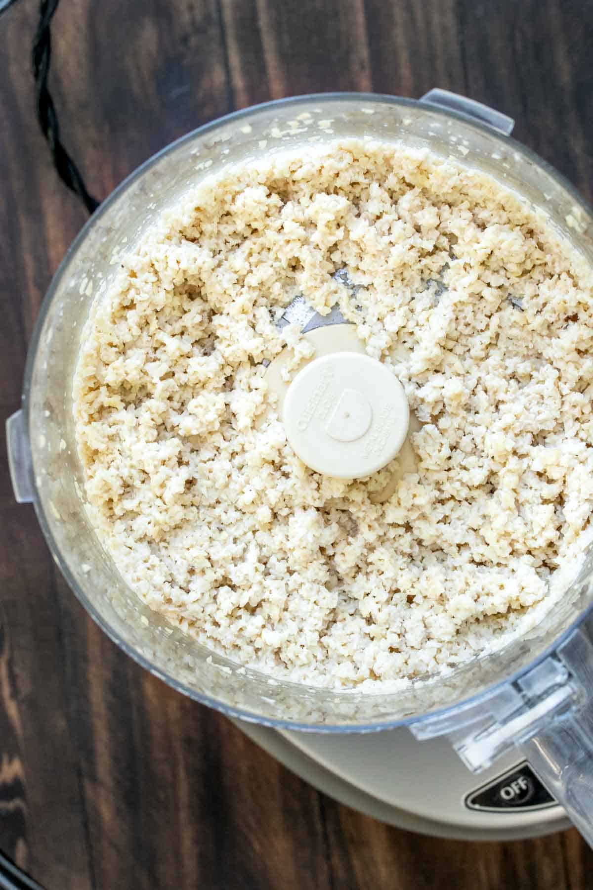 Overhead view of a food processor filled with a feta cheese like mixture