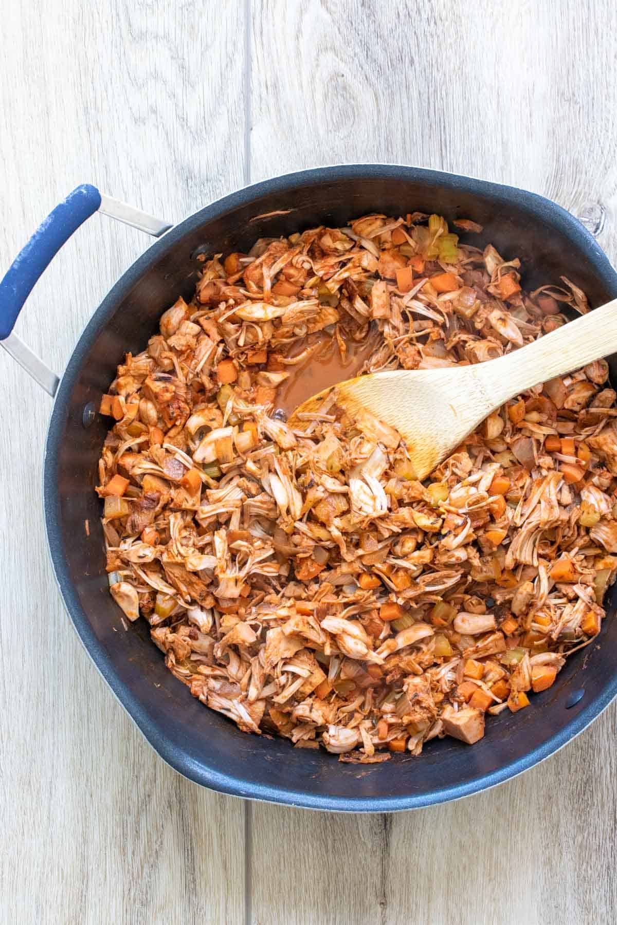 Pan with a wooden spoon mixing a vegetable bolognese sauce