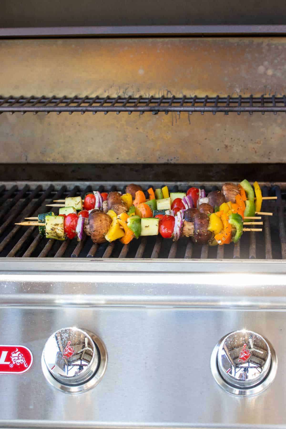 Veggie kabobs being grilled on an outdoor grill.