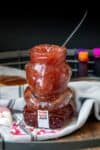 A bear shaped jar of strawberry jam on a grey towel